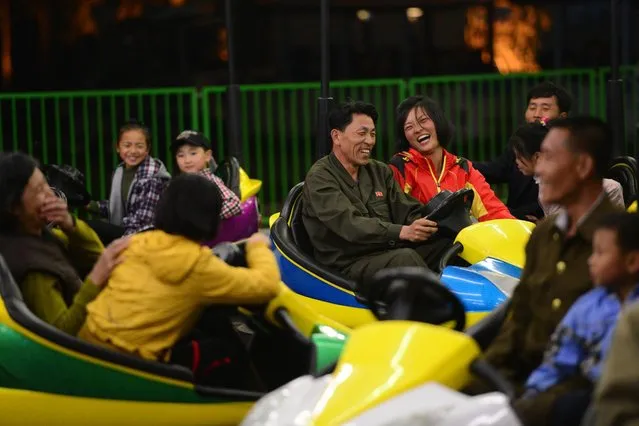 Two people share a rare laugh at the Pyongyang Amusement park, which features bumper cars, a rollercoaster and other rides. (Photo by Gavin John/Mediadrumworld.com)