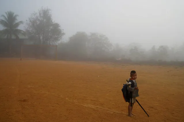 A hill tribe student walks through early morning mist as he arrives at the Ban Mae Chan Tha Border Patrol Police School, at Umphang district, in Tak province, Thailand, February 6, 2017. (Photo by Athit Perawongmetha/Reuters)