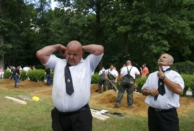 Gravediggers change into their formal clothes after the first Hungarian grave digging championship in Debrecen, Hungary, June 3, 2016. (Photo by Laszlo Balogh/Reuters)