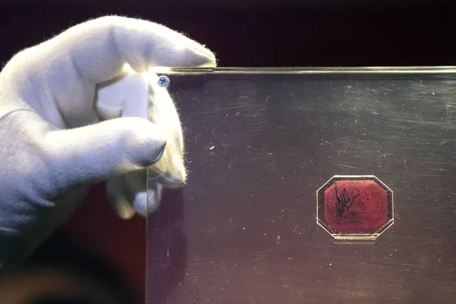 An employee of Sotheby's auction house holds a case containing the sole-surviving “British Guiana One-Cent Magenta” stamp dating from 1856, on June 2, 2014 in London, England. The unique stamp is expected to fetch 20 million USD when auctioned in New York, USA on June 17, 2014. The stamp was initially discovered in 1873 by a 12-year old Scottish boy living in British Guiana, South America who sold it to a local stamp collector for several shillings. (Photo by Oli Scarff/Getty Images)