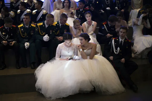 Students of military schools rest after dancing during an annual ball in Moscow, Russia, Tuesday, December 17, 2019. More than 1,000 students from military schools travelled from all over Russia to Moscow to take part in the ball. (Photo by Alexander Zemlianichenko/AP Photo)