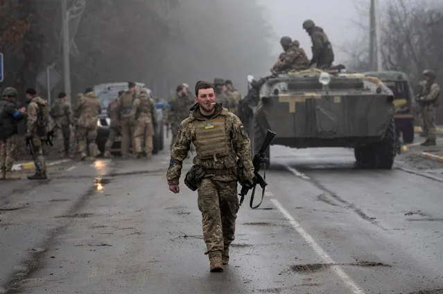 A Ukrainian army soldier walks after a military sweep to search for possible remnants of Russian troops after their withdrawal from villages in the outskirts of Kyiv, Ukraine, Friday, April 1, 2022. (Photo by Rodrigo Abd/AP Photo)