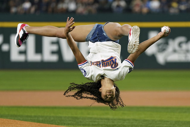 Olympic gold medal-winning gymnast Hezly Rivera does a flip before throwing out a ceremonial first pitch before a baseball game between the Texas Rangers and the New York Yankees, Wednesday, September 4, 2024, in Arlington, Texas. (Photo by Jeffrey McWhorter/AP Photo)