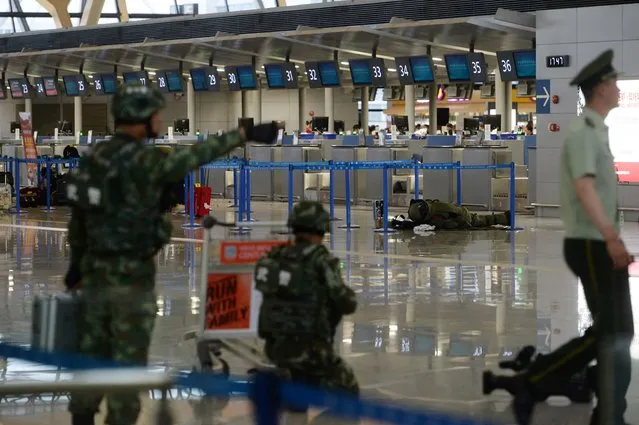 A paramilitary bomb disposal expert (background R) inspects luggage left near a check-in counter after an explosion at Pudong Airport in Shanghai on June 12, 2016. A blast caused by “home-made” explosives injured four people and sparked a major security alert at the main international airport in China's commercial hub of Shanghai on June 12, according to the operator and state media. (Photo by AFP Photo/Stringer)