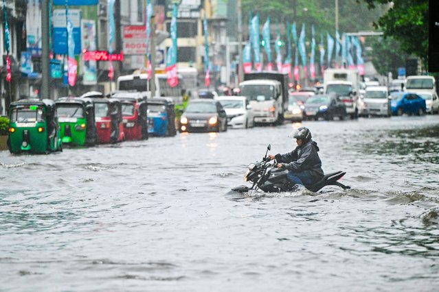 A man rides a motorbike through a flooded street after heavy rains in Colombo on June 2, 2024. Flash floods, mudslides and falling trees have killed at least 14 people in Sri Lanka as the island nation is battered by monsoon storms, the country's disaster centre said. (Photo by Ishara S.Kodikara/AFP Photo)