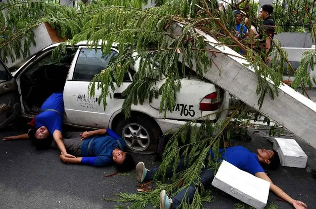 Volunteers, acting as injured passengers of a taxi, lay on a pavement during an earthquake drill as part of the metro-wide quake drill in Manila on June 22, 2016. The drill is being implemented as part of the preparation for the so-called “big one”. The Philippines is regularly hit by quakes due to its location along the so-called chain of fire of islands of the Pacific Ocean that were created by volcanic activity. (Photo by Ted Aljibe/AFP Photo)