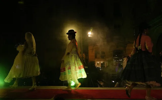 Aymara women models a creation by a local designer at a Chola fashion in La Paz, Bolivia, Thursday, October 14, 2021. The fashion show is designed to promote the Andean style and beauty of Aymara women, who are commonly called Cholitas in Bolivian slang. (Photo by Juan Karita/AP Photo)
