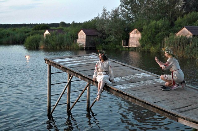 Women wearing traditional Ukrainian clothes attend Kupala night celebrations after volunteering to clear debris from destroyed buildings, near Yagidne, Chernihiv region on July 8, 2023, amid the Russian invasion of Ukraine. (Photo by Genya Savilov/AFP Photo)