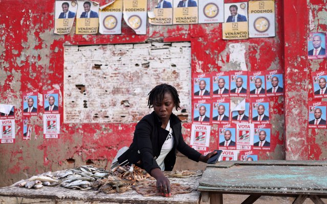 A woman prepares her stall, with election posters in the background, ahead of the presidential elections, in the suburb of Katembe, Maputo, Mozambique on October 7, 2024. (Photo by Siphiwe Sibeko./Reuters)