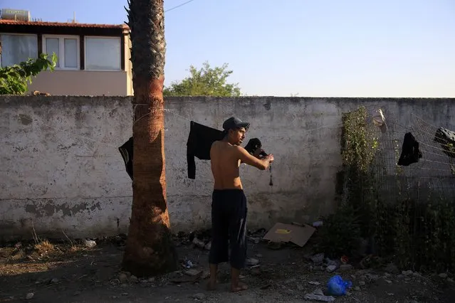 A migrant from Pakistan hangs his washed clothes to dry in the garden of a deserted hotel on the Greek island of Kos, August 13, 2015. (Photo by Alkis Konstantinidis/Reuters)