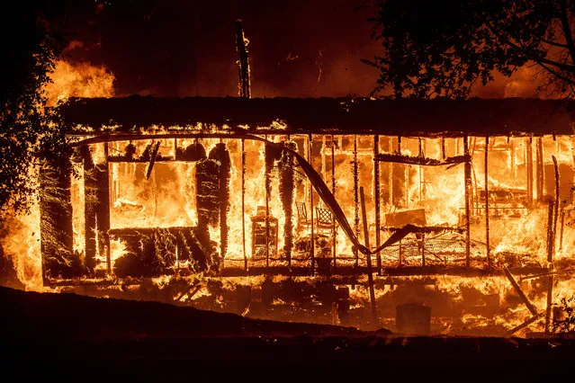 Flames consume a home as the Kincade Fire tears through the Jimtown community of Sonoma County, Calif., on Thursday, October 24, 2019. (Photo by Noah Berger/AP Photo)