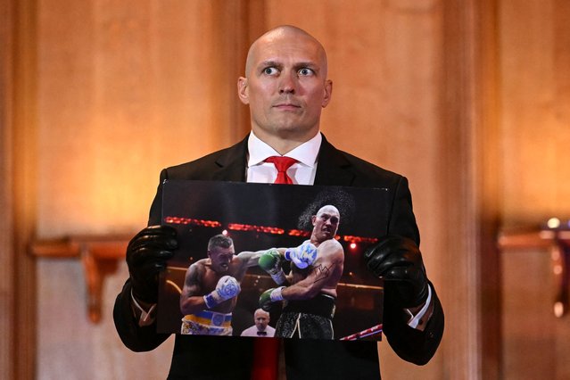 Ukraine's Oleksandr Usyk holds a photograph signed by Britain's Tyson Fury during a press conference, in central London, on October 23, 2024, ahead of his undisputed heavyweight world championship rematch taking place on December 21, 2024 in Riyadh, Saudi Arabia. (Photo by Justin Tallis/AFP Photo)