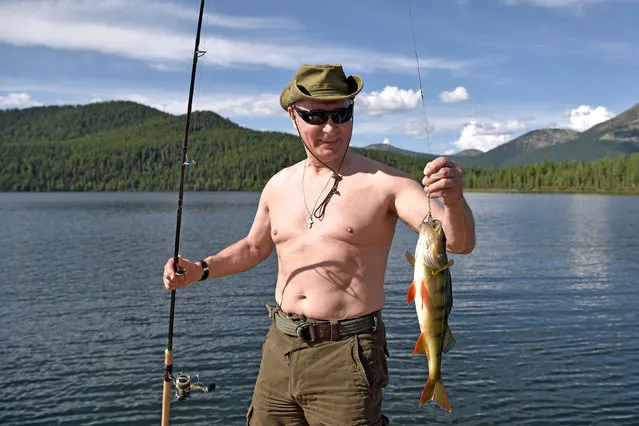 Russian President Vladimir Putin holds a fish he caught during the hunting and fishing trip which took place on August 1-3 in the republic of Tyva in southern Siberia, Russia, in this photo released by the Kremlin on August 5, 2017. (Photo by Alexei Nikolsky/Reuters/Sputnik/Kremlin)