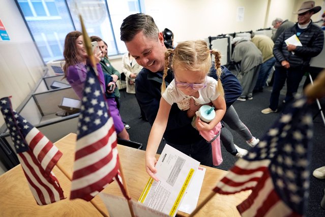 US Rep. Zach Nunn holds his daughter Aliya as he casts an early ballot in Des Moines, Iowa, on Wednesday, October 16, 2024. (Photo by Charlie Neibergall/AP Photo)