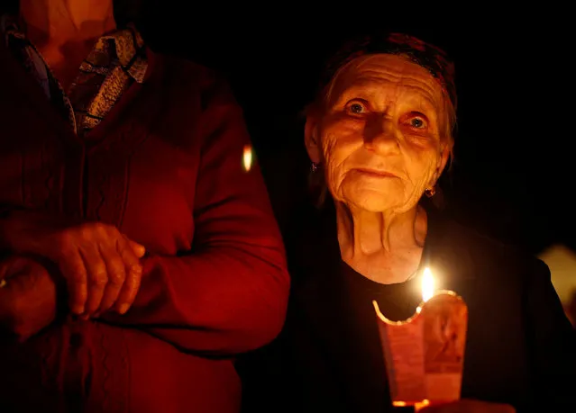 A woman with candle takes part in a service after the annual Icon of the Mother of God procession in the village of Budslav, Belarus, early July 2, 2016. (Photo by Vasily Fedosenko/Reuters)
