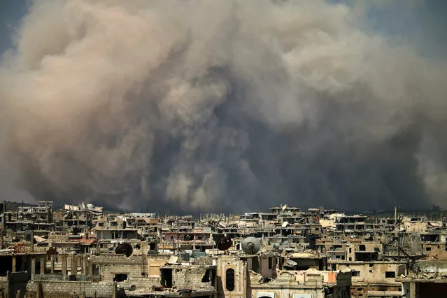 Smoke billows following a reported air strike on a rebel-held area in the southern Syrian city of Daraa, on August 8, 2017. (Photo by Mohamad Abazeed/AFP Photo)