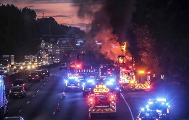 Firefighters battle a fire from a tractor trailer  on I-285 in DeKalb County early Friday, July 1, 2022 in DeKalb County, Ga.  The fire was extinguished, but its impact on traffic lingered into the heart of the morning commute. (Photo by John Spink/Atlanta Journal-Constitution via AP Photo)