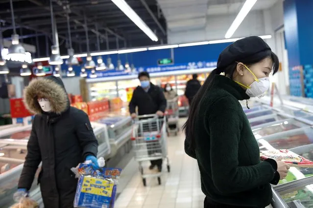 People wearing face masks look for products at a supermarket, as the country is hit by an outbreak of the new coronavirus, in Beijing, China on February 19, 2020. (Photo by Carlos Garcia Rawlins/Reuters)
