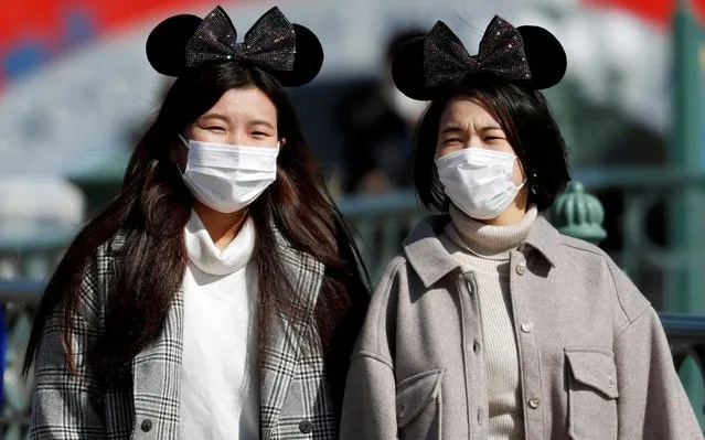 Visitors wearing protective face masks and Mickey Mouse costumes, following an outbreak of the coronavirus, are seen outside Tokyo Disneyland in Urayasu, east of Tokyo, Japan on February 28, 2020. (Photo by Issei Kato/Reuters)