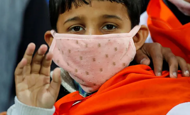 A boy wears a mask as he waits for the start of the first One-day International cricket match between India and South Africa, amid coronavirus fears, at Himachal Pradesh Cricket Association Stadium in Dharamsala, India on March 12, 2020. (Photo by Adnan Abidi/Reuters)