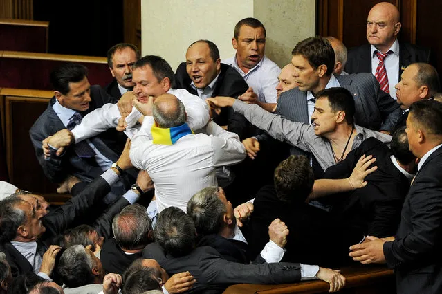 Opposition lawmakers clash with deputies of parliament's majority during a session of the Ukrainian Parliament, in Kiev, Ukraine, 24 March 2012.  The brawl broke out when deputies were controversially discussing a bill on granting Russian being the official language. (Photo by Aleksandr Svetlov/EPA)