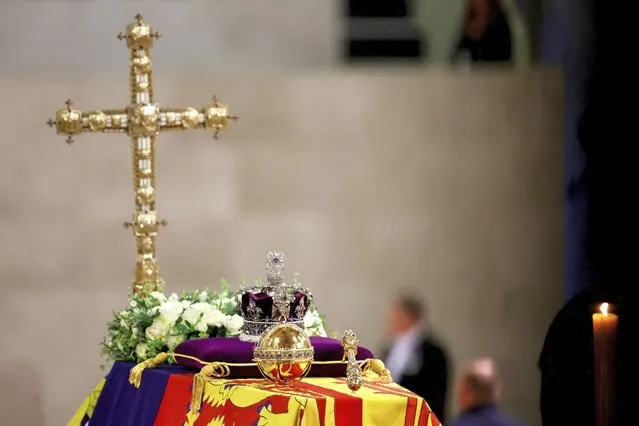 A view of Queen Elizabeth's coffin, draped in the Royal Standard, with the Imperial State Crown and the Sovereign's orb and sceptre, and flowers on top, following her death, during her lying in state at Westminster Hall, in Westminster Palace, in London, Sunday, September 18, 2022. (Photo by Sarah Meyssonnier/Pool Photo via AP Photo)