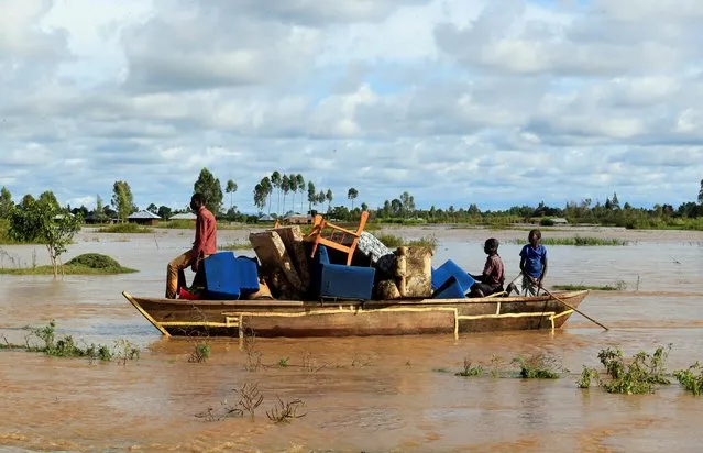 Residents use a boat to carry their belongings through the waters after their homes were flooded as the River Nzoia burst its banks and due to heavy rainfall and the backflow from Lake Victoria, in Budalangi within Busia County, Kenya on May 3, 2020. (Photo by Thomas Mukoya/Reuters)
