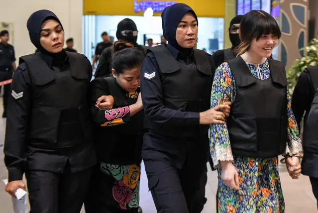 Vietnamese defendant Doan Thi Huong (R) and Indonesian defendant Siti Aishah (2nd, L) are escorted by police personnel at the low- cost carrier Kuala Lumpur International Airport 2 (KLIA2) in Sepang during a visit to the scene of the murder as part of the Shah Alam High Court trial process on October 24, 2017, for their alleged role in the assassination of Kim Jong- Nam. Indonesian Siti Aisyah, 25, and Huong, 28, have been charged with the murder of Kim Jong- Nam, the estranged half- brother of North Korean leader Kim Jong- Un, at Kuala Lumpur International Airport 2 (KLIA2) in February. (Photo by Mohd Rasfan/AFP Photo)