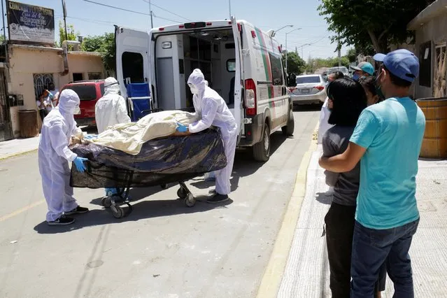 Paramedics transport the body of a man who died of the coronavirus disease (COVID-19) before being transferred to a hospital as his relatives observe, in Ciudad Juarez, Mexico on May 26, 2020. (Photo by Jose Luis Gonzalez/Reuters)