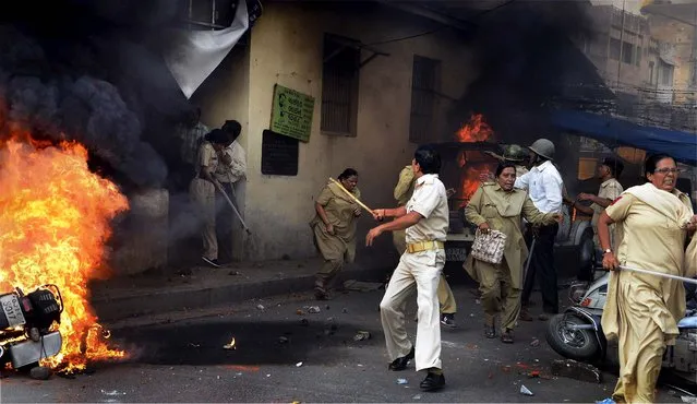 Police personnel run after their police station in Ahmadabad, India, was attacked by a mob during a protest against the anti-Islam film “Innocence of Muslims”, on October 3, 2012. (Photo by Associated Press)