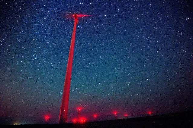 A view of meteors lighting up the night sky above a wind turbine at 'Saint Nikola' wind park near the Kavarna, some 500km from Sofia, Bulgaria, 12 August 2016. The Perseid meteor shower occurs every year in summer when the Earth passes through debris and dust of the 109P/Swift-Tuttle comet. The Perseids, one of the brightest meteorite swarms, consist of a multitude of stellar particles which due to their high speed glow up and burn by entering Earth's atmosphere. (Photo by Vassil Donev/EPA)