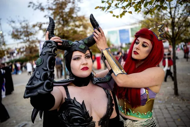 Cosplayers dressed as Maleficent and Ariel from Disney adjust their costumes at the MCM Comic Con at ExCeL exhibition centre in London on October 28, 2017. (Photo by Tolga Akmen/AFP Photo)