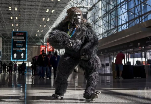 A man in a gorilla costume runs through the hallways of the Jacob K. Javits Convention Center during the first day of New York Comic Con in New York, New York, USA, 06 October 2022. The annual event offers pop culture fans exhibitions and displays of popular video games, movies and comic books and many people attend dressed as their favorite fictional character. (Photo by Justin Lane/EPA/EFE)