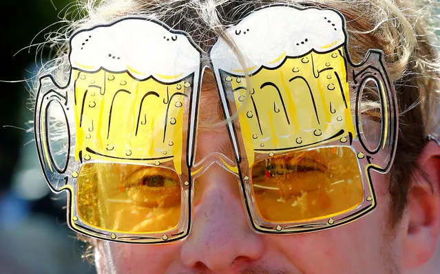 A reveller looks through beer mug-shaped sunglasses during the Street Parade dance music event in Zurich, Switzerland August 13, 2016. (Photo by Arnd Wiegmann/Reuters)