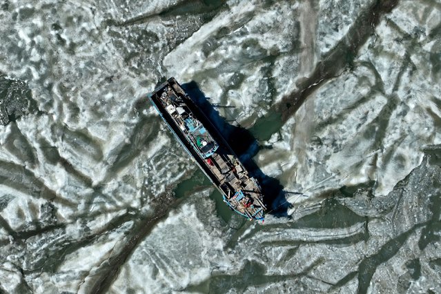 A fishing boat is surrounded by sea ice in Jiaozhou bay, in Qingdao, in China's eastern Shandong province on February 8, 2025. (Photo by AFP Photo/China Stringer Network)