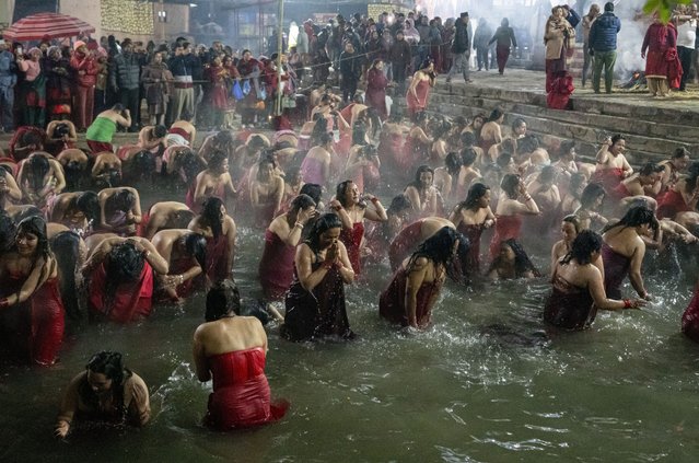 Devotees take holy dips in the Sali river during Madhav Narayan festival in Sankhu, northeast of Kathmandu, Nepal, Monday, January 13, 2025. (Photo by Niranjan Shrestha/AP Photo)