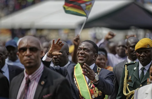 Zimbabwe's President Emmerson Mnangagwa, center, gestures to the cheering crowd as he leaves after the presidential inauguration ceremony in the capital Harare, Zimbabwe Friday, November 24, 2017. Mnangagwa was sworn in as Zimbabwe's president after Robert Mugabe resigned on Tuesday, ending his 37-year rule. (Photo by Ben Curtis/AP Photo)