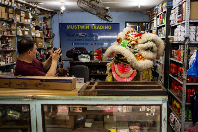 A man takes a picture of a lion dancer inside their store during Lunar New Year celebrations in Binondo, Manila, Philippines, on January 29, 2025. (Photo by Eloisa Lopez/Reuters)