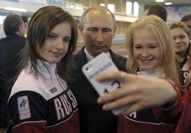 Russian President Vladimir Putin (C) poses for a picture with youths who took part in the Nanjing 2014 Youth Olympic Games, as he visits a local Olympic youth sports school in Cheboksary, October 9, 2014. (Photo by Alexei Druzhinin/Reuters/RIA Novosti/Kremlin)