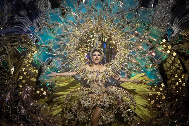 Corina Mrazek Gonzalez presents a design by Santi Castro, prior to being proclaimed new Queen of Carnival during the Election of the Queen of Carnival gala in Santa Cruz de Tenrife on the Spanish Canary island of Tenerife, on February 7, 2023. The candidates for Queen of the Carnival wear costumes of more than five-meter high and over 80 kilos in weight. Considered one of the most popular and well-known carnival in the world, following Rio de Janeiro (Brazil), the Carnival of Santa Cruz de Tenerife offers festivities that range from the election of the Carnival Queen, children and adult murgas (satirical street bands), comparsas (dance groups) to performances on the streets. (Photo by Desiree Martin/AFP Photo)