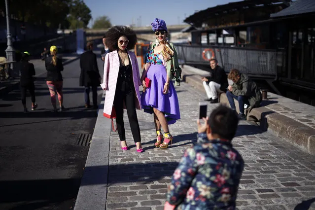 Fashion lovers pose along the Seine river before the start of Indian designer Manish Arora's Spring-Summer 2016 ready-to-wear fashion collection, presented during the Paris Fashion Week in Paris, France, Thursday, October 1, 2015. (Photo by Jerome Delay/AP Photo)