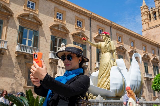 A tourist takes a selfie in front of the Palermo cathedral, in Palermo, Italy, on May 14, 2025. (Photo by Igor Petyx/Reuters)