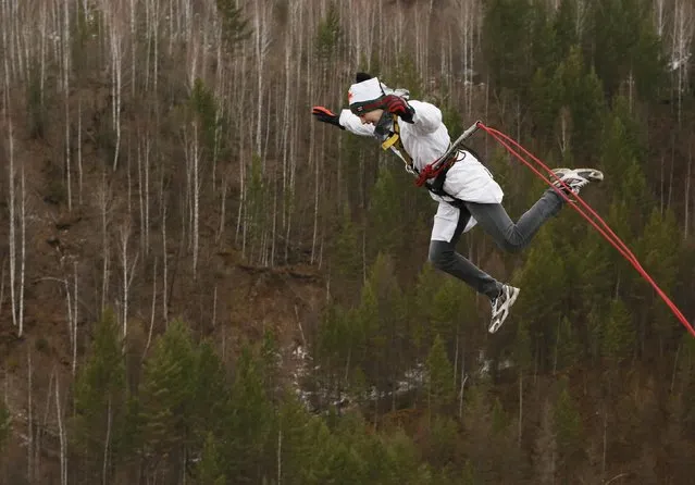 A member of the amateur rope-jumping group “Exit Point” jumps from a 44-metre high (144-ft) water pipe bridge in the Siberian Taiga area outside Krasnoyarsk, November 2, 2014. (Photo by Ilya Naymushin/Reuters)