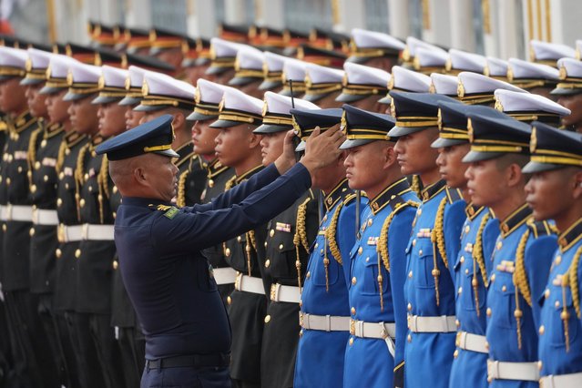 A Thai Air Force officer adjusts the cap of a member of an honor guard in preparation for the arrival of Indonesian President Prabowo Subianto at the Government house in Bangkok, Thailand, Monday, May 19, 2025. (Photo by Sakchai Lalit/AP Photo)