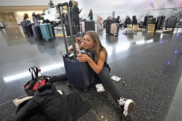 Traveler Shea Cooper, of Lone Peak Cheer, applies makes up as she waits in Salt Lake City International Airport after their flight was canceled by snow, Wednesday, Feb.ruary 22, 2023, in Salt Lake City. Brutal winter weather hammered the northern U.S. Wednesday with “whiteout” snow, dangerous wind gusts and bitter cold, shutting down roadways, closing schools and businesses and prompting dire warnings for people to stay home. (Photo by Rick Bowmer/AP Photo)