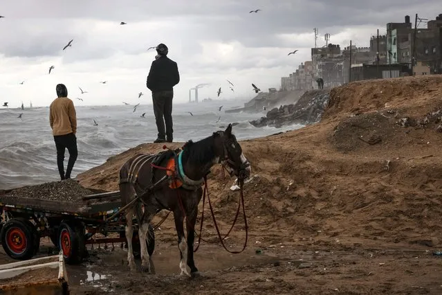 Palestinians gather by the Mediterranean Sea in Gaza City during a stormy weather on February 8, 2023. (Photo by Mahmud Hams/AFP Photo)