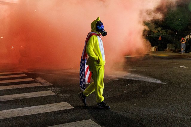 A protester walks amid tear gas and red smoke during a protest against the U.S. President Donald Trump administration's immigration policies, outside an ICE detention facility in Portland, Oregon, U.S., on September 1, 2025. (Photo by John Rudoff/Reuters)