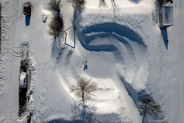 A picture taken with a drone shows a blanket of snow covers an amphitheatre-like open air community structure in Aiton, Transylvania, Romania, 05 February 2023. (Photo by Gabor Kiss/EPA/EFE)