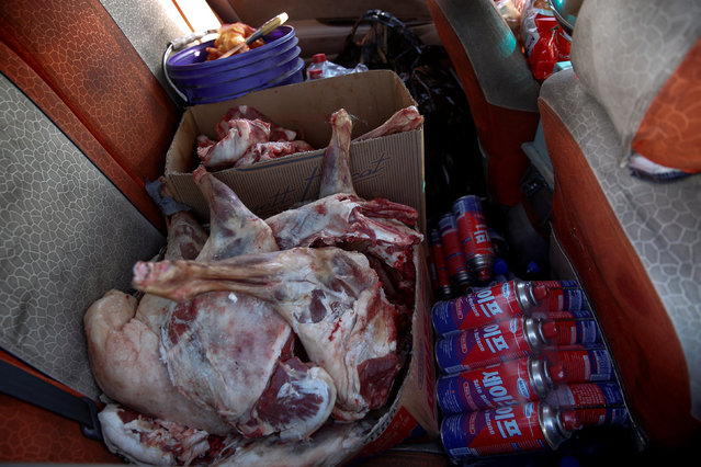 Sheep meat and cooking gas are seen in the back of a van on the road to the Mongolia-China border at Khanbogd Soum in the Gobi desert, Mongolia, October 31, 2017. Smaller vehicles travel up and down the highway to the Mongolia-China border selling water and food to coal truck drivers who are many days away from a rest stop. (Photo by Bazarsukh Rentsendorj/Reuters)