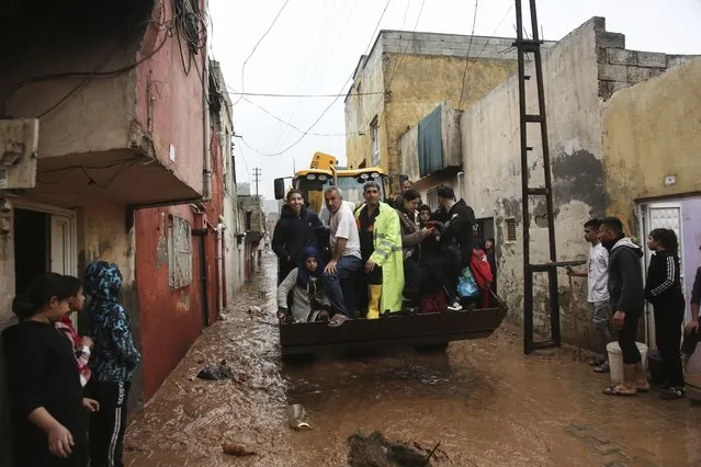 People are rescued during floods after heavy rains in Sanliurfa, Turkey, Wednesday, March 15, 2023. (Photo by Hakan Akgun/DIA via AP Photo)